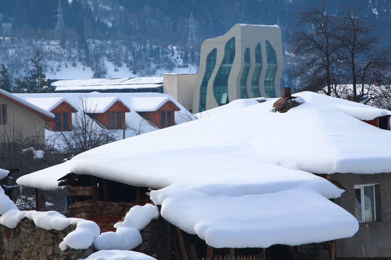 Snow-covered roofs and Caucasus mountains around Mestia in winter