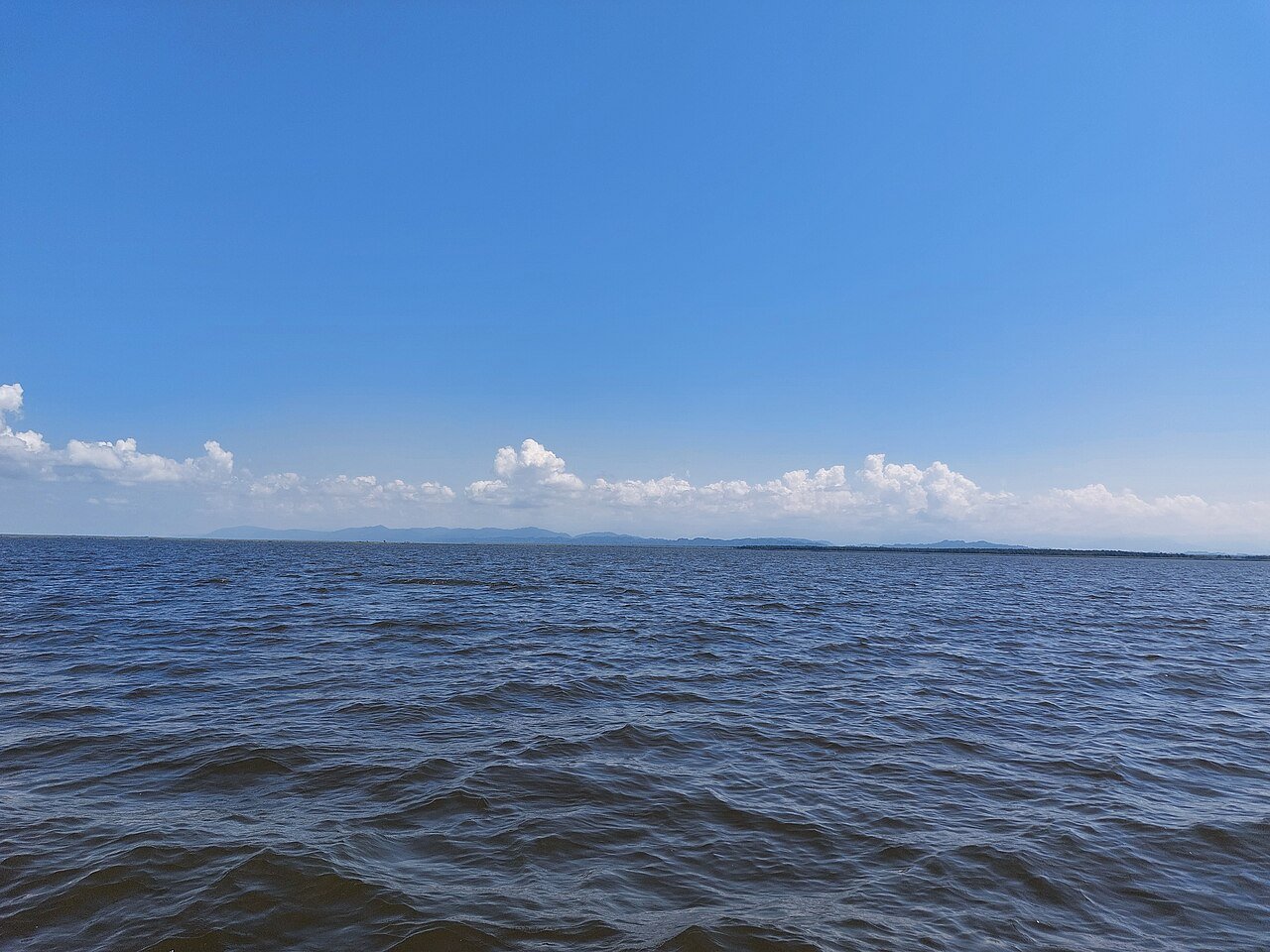Calm Paliastomi Lake and green shoreline north of Ureki