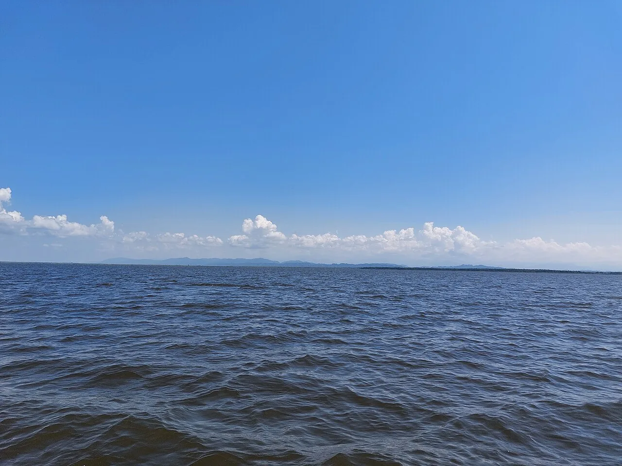 Calm Paliastomi Lake and green shoreline north of Ureki